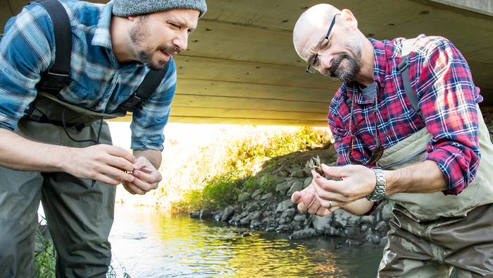 Researchers Eric Larson (left) and Christopher Taylor observe a crayfish. (L. Brian Stauffer)